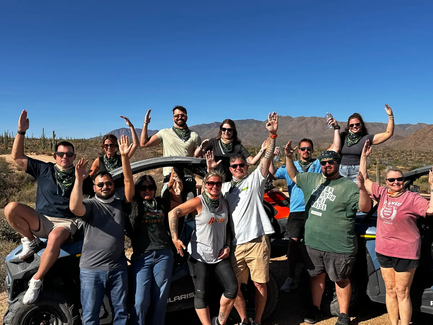 Corporate team in matching bandanas celebrating on a Scottsdale desert UTV tour