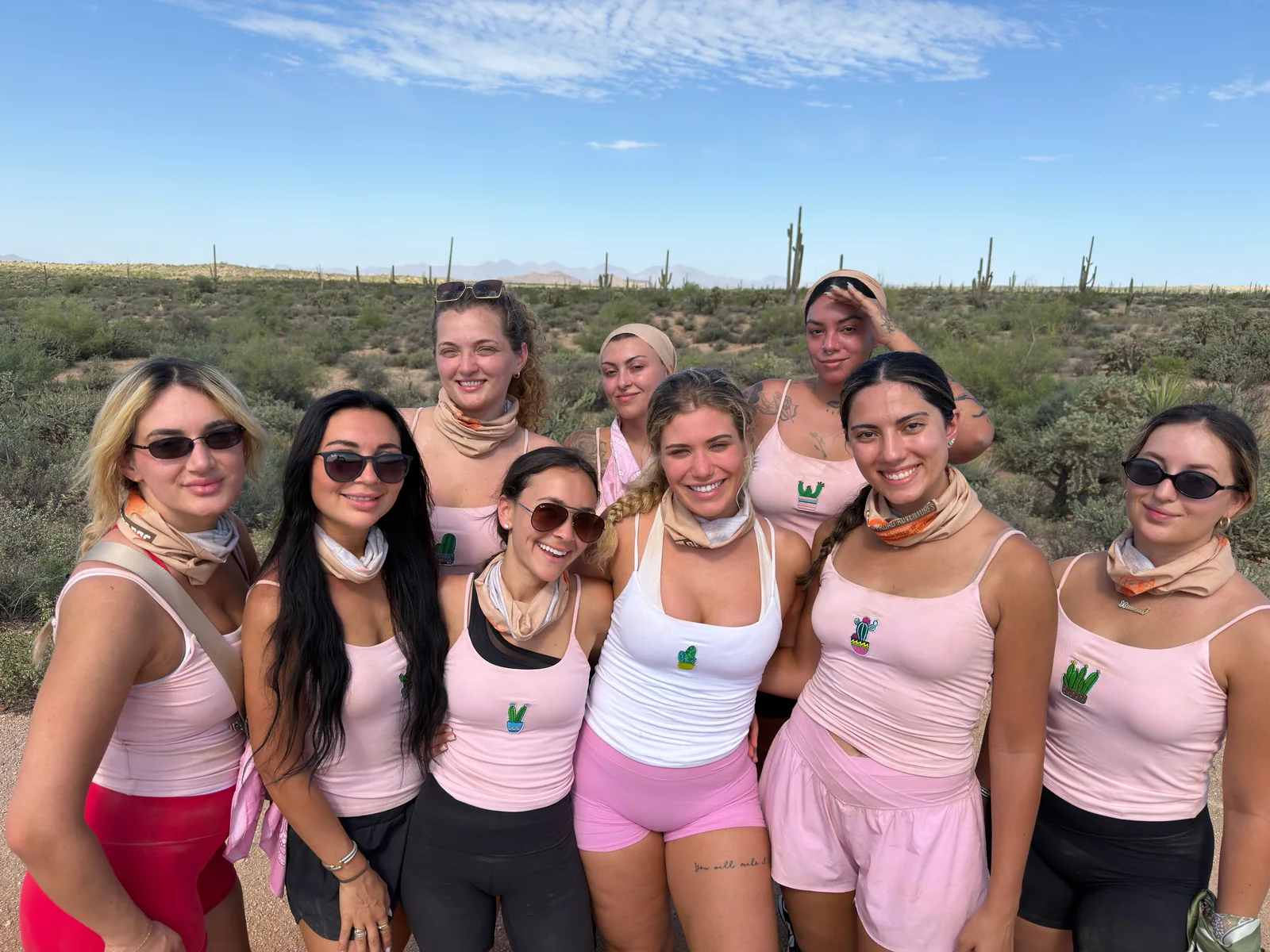 Bachelorette party in matching pink tanks and Desert Dog Offroad Adventures gaiters among the saguaros near Scottsdale